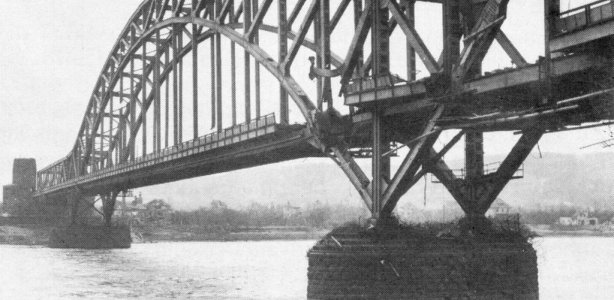 De beschadigde brug, kort na de slag. Foto door een onbekende fotograaf van het Amerikaanse leger, Public domain, via Wikimedia Commons brug bij Remagen